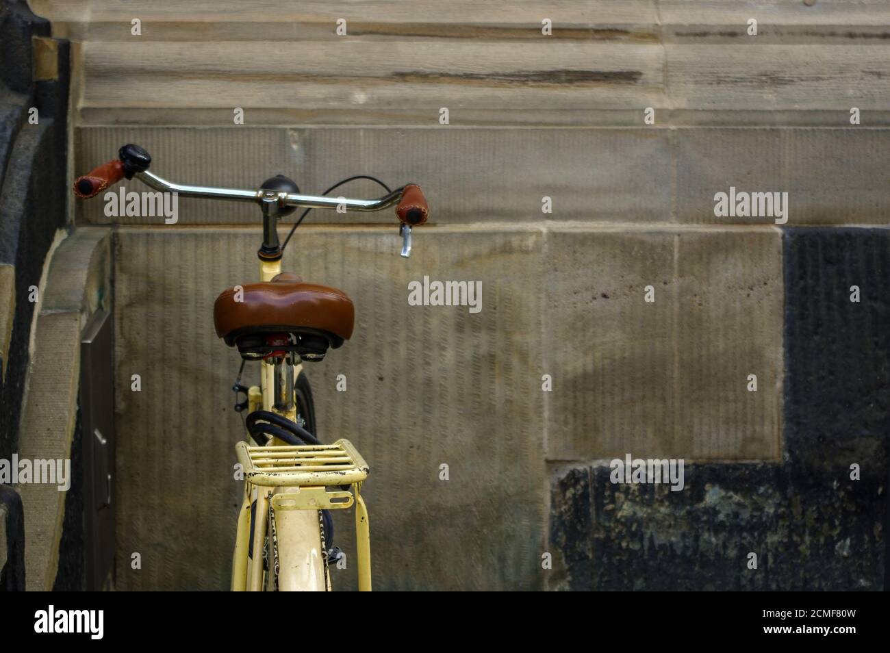 Dettagli del vecchio giallo bicicletta. il sedile in pelle con ammortizzatori e ruota Foto Stock