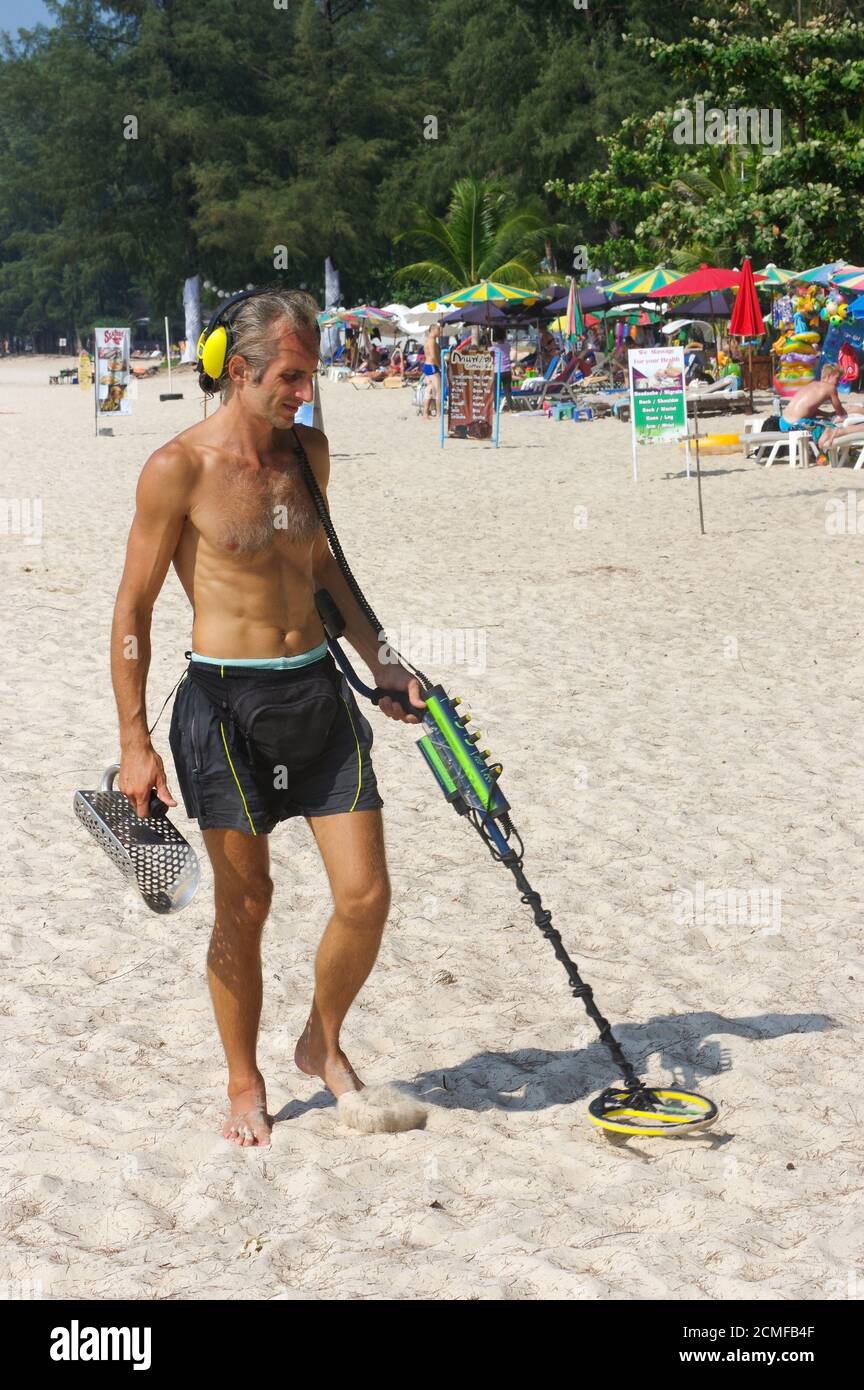 PHUKET, THAILANDIA - 25 MARZO 2016: Cacciatore di tesori con metal detector sulla spiaggia Foto Stock