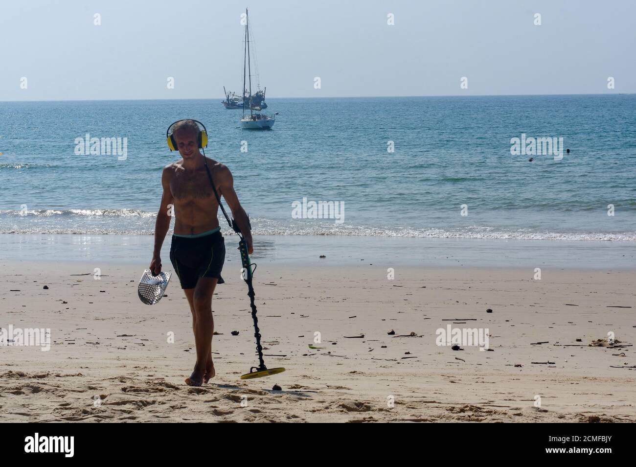 Cacciatore di tesori con metal detector in giornata di sole sulla spiaggia Foto Stock