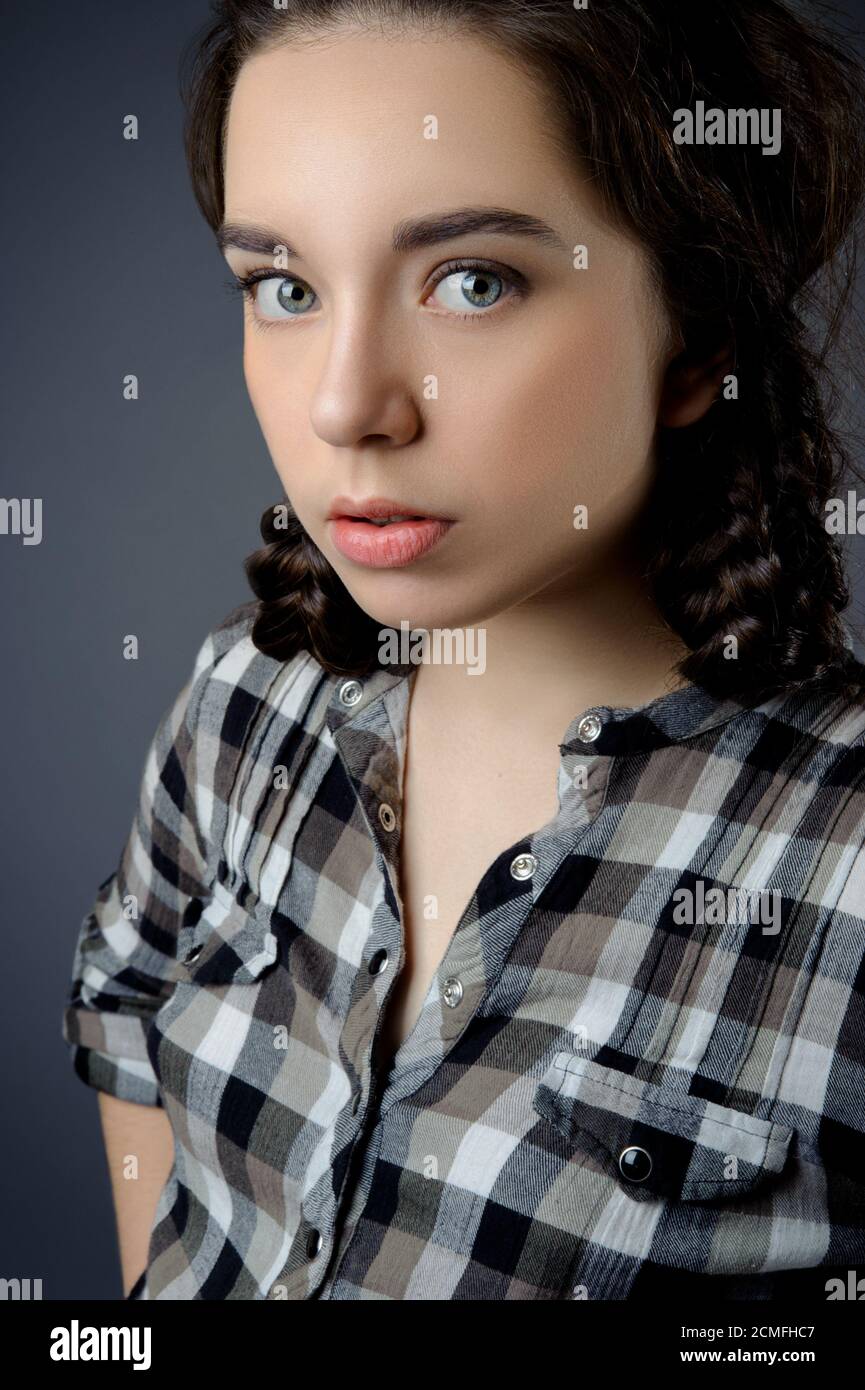 Ritratto di bellezza di una bella bruna ragazza su sfondo grigio. Foto Stock