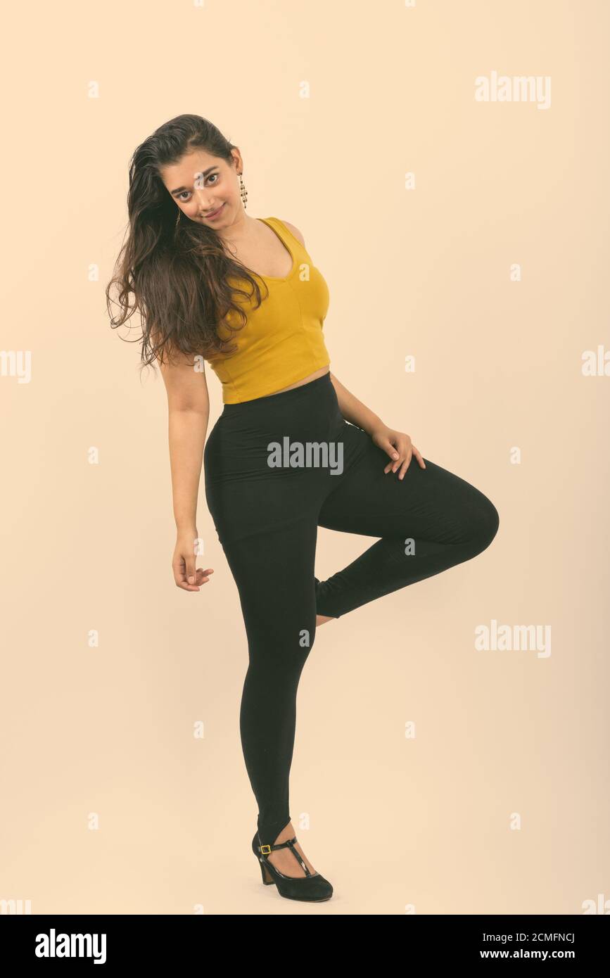 Corpo pieno colpo di giovane bella donna indiana in posa con una gamba in alto Foto Stock