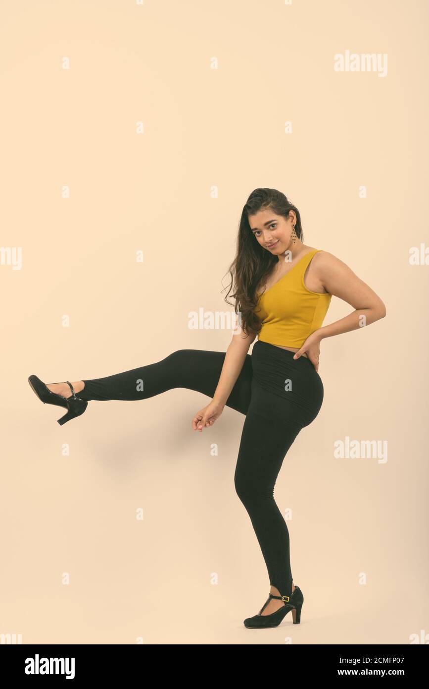 Corpo pieno colpo di giovane bella donna indiana in posa con una gamba in alto Foto Stock