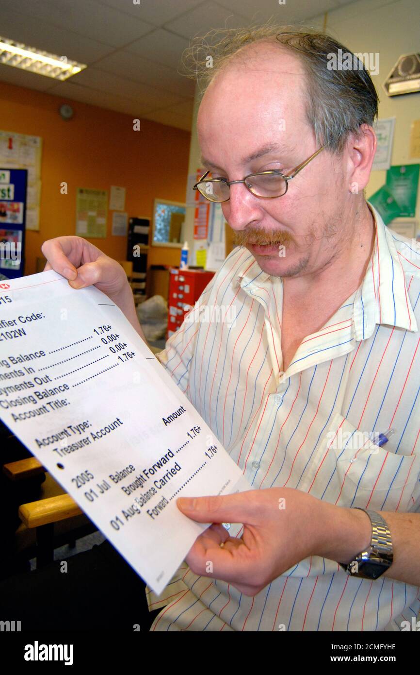 Uomo con disabilità di apprendimento che legge grande stampa dichiarazione bancaria; centro di comunità; Bradford; Yorkshire UK Foto Stock