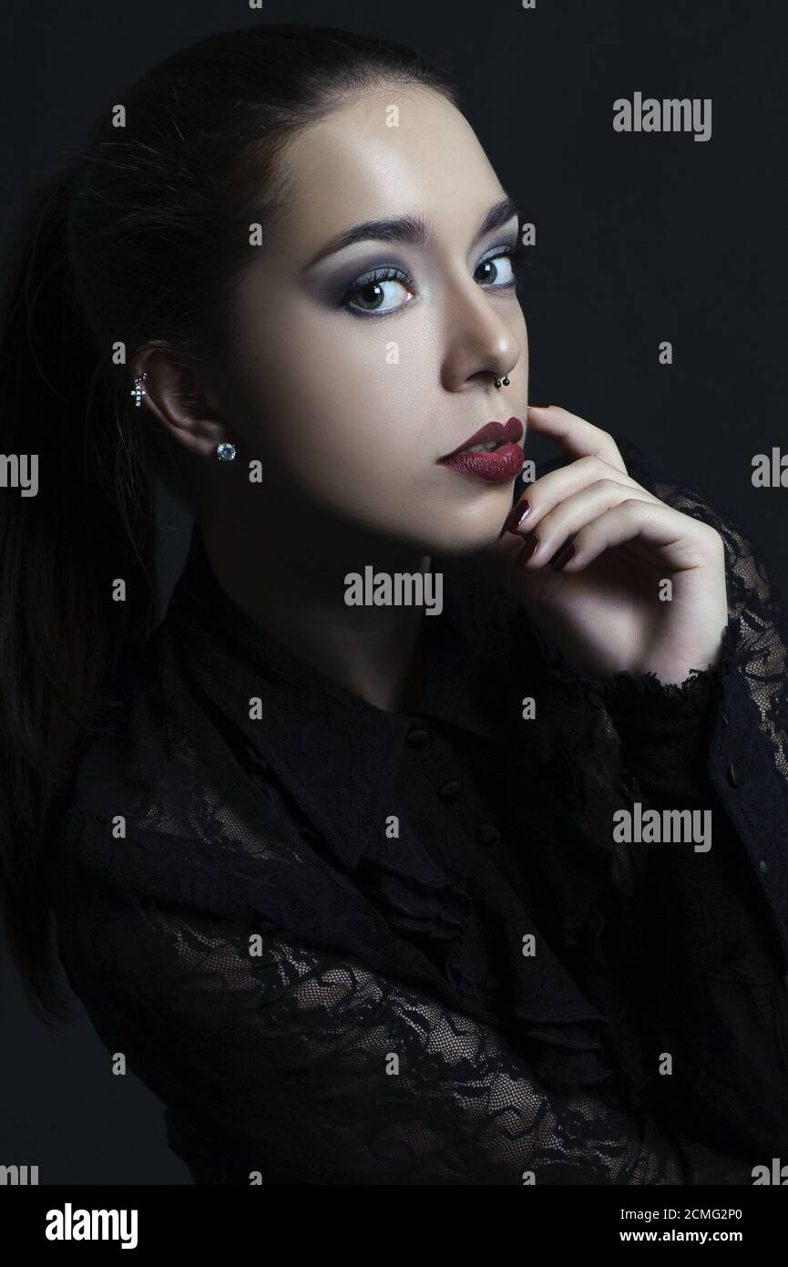 Ritratto di una bella giovane donna su sfondo nero. Foto Stock