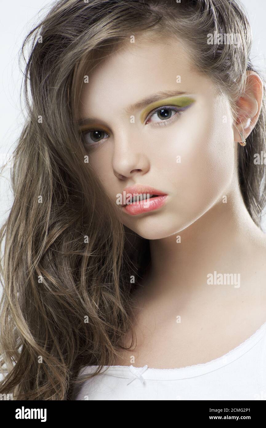 Ritratto di bellezza di una giovane ragazza con trucco luminoso e capelli lunghi. Foto Stock