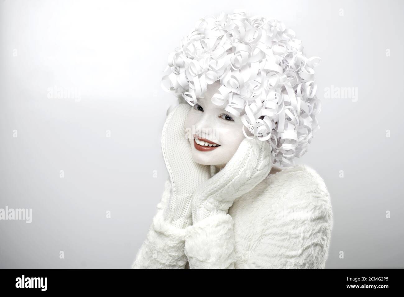 Ritratto di una ragazza carina con un viso bianco e capelli ricci. Foto Stock