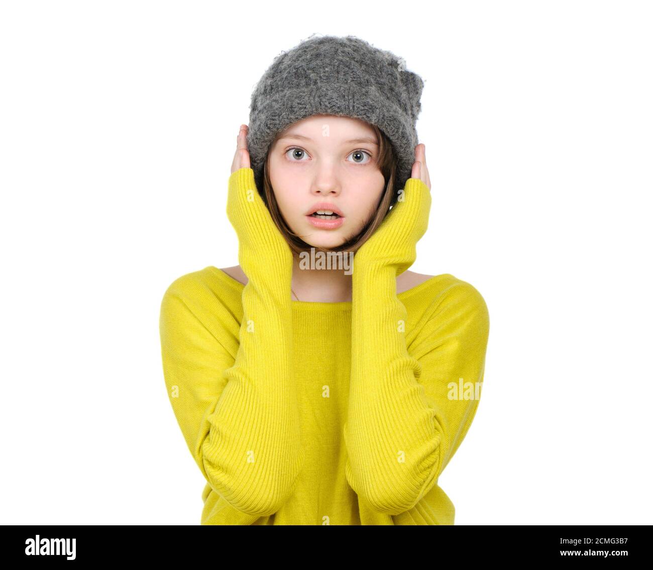 Ritratto di ragazza teen sorpresa (spaventato) in un cappello a maglia e maglia brillante. Foto Stock