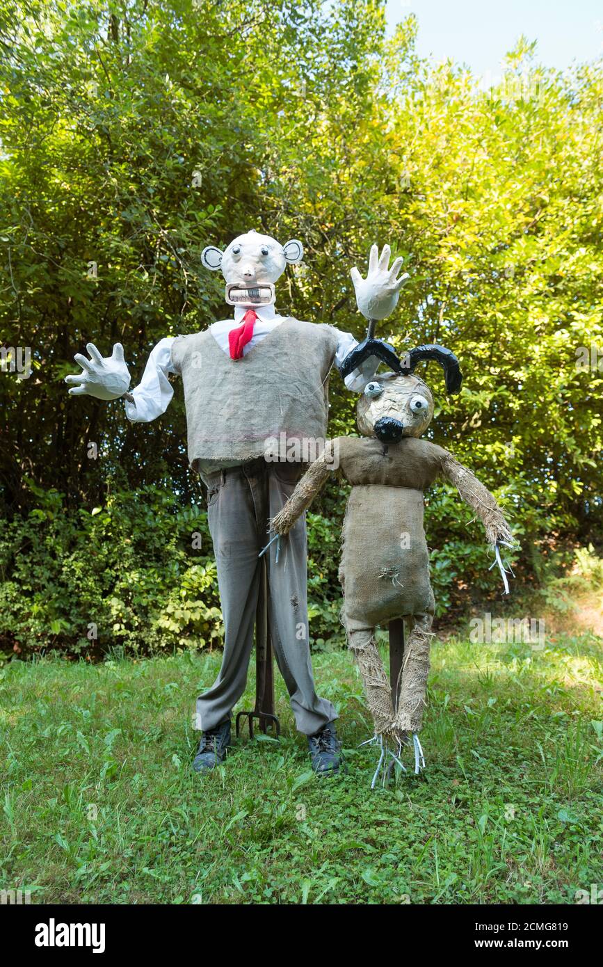 Vista insolita a grandezza naturale sulla corsia di campagna vestita di scarecrow Indossare una divisa elegante in giardino anteriore Wallis e Gromit lavorato a maglia ponticello Foto Stock