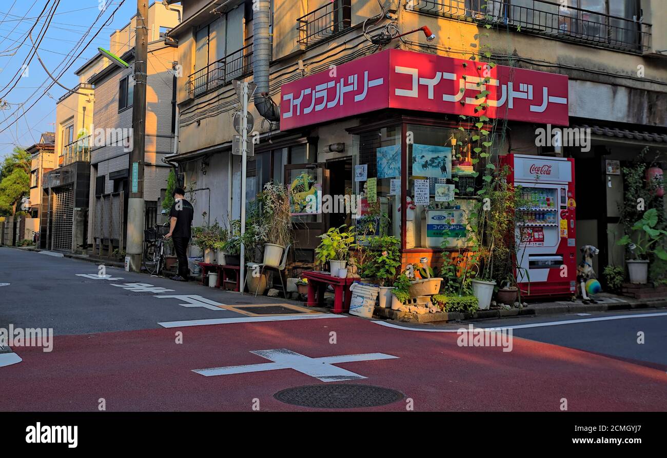 Vista esterna di una lavanderia a gettoni vintage in un Area suburbana di Tokyo in un pomeriggio limpido in estate (il segno rosso sulla parte superiore si traduce direttamente in 'moneta Foto Stock