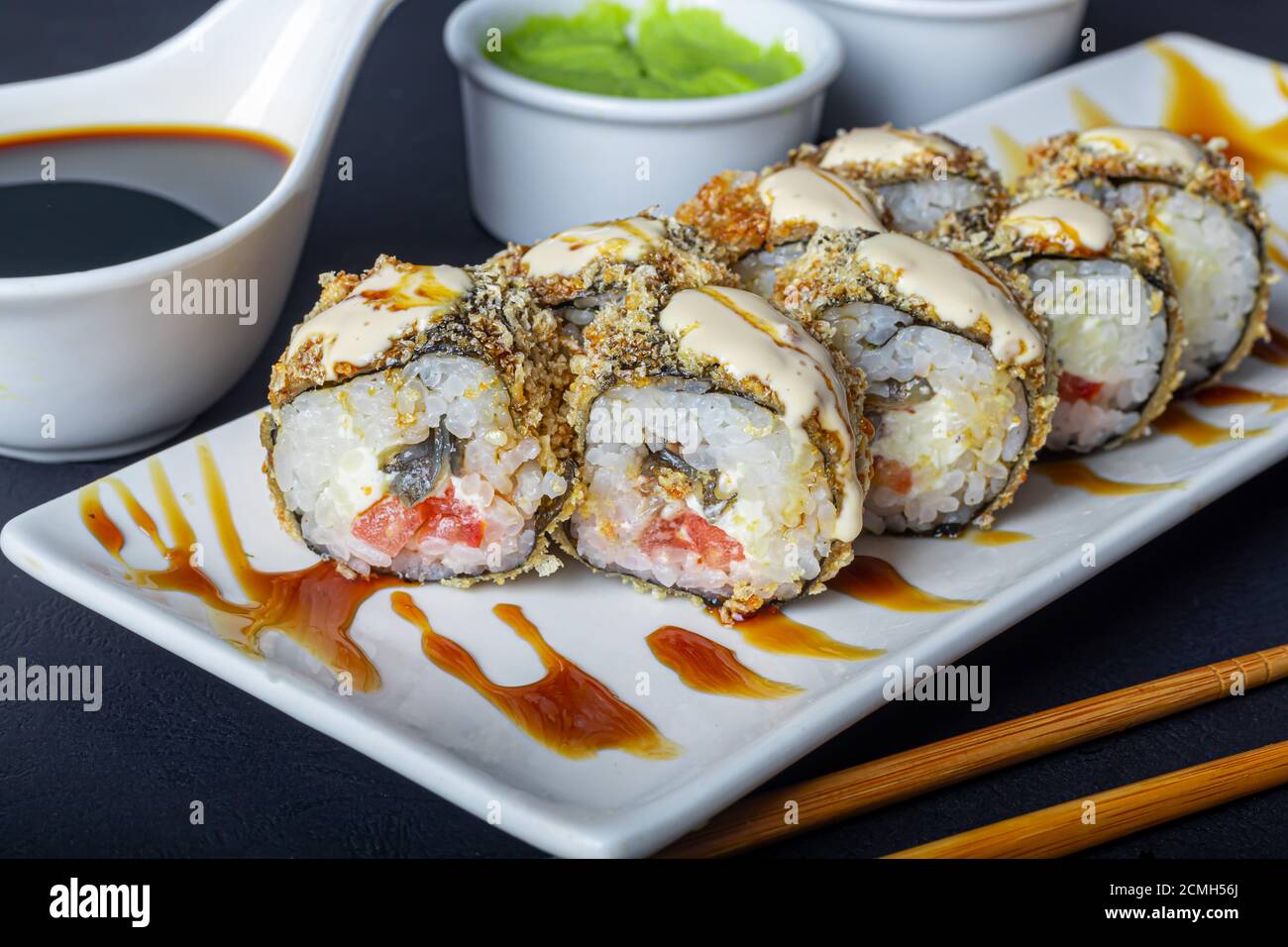 Sushi Set Uramaki, California, Philadelphia, su un piatto bianco. Zenzero e  wasabi nelle vicinanze. Salsa di soia in un recipiente bianco. Su sfondo  scuro. Spazio di copia Foto stock - Alamy