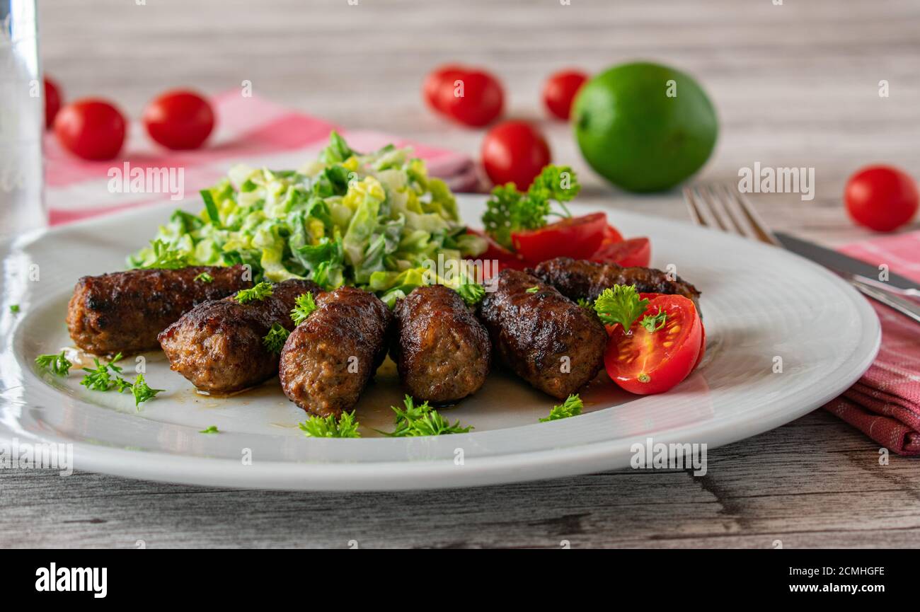 involtini di carne tritati piccanti con insalata su un piatto Foto Stock