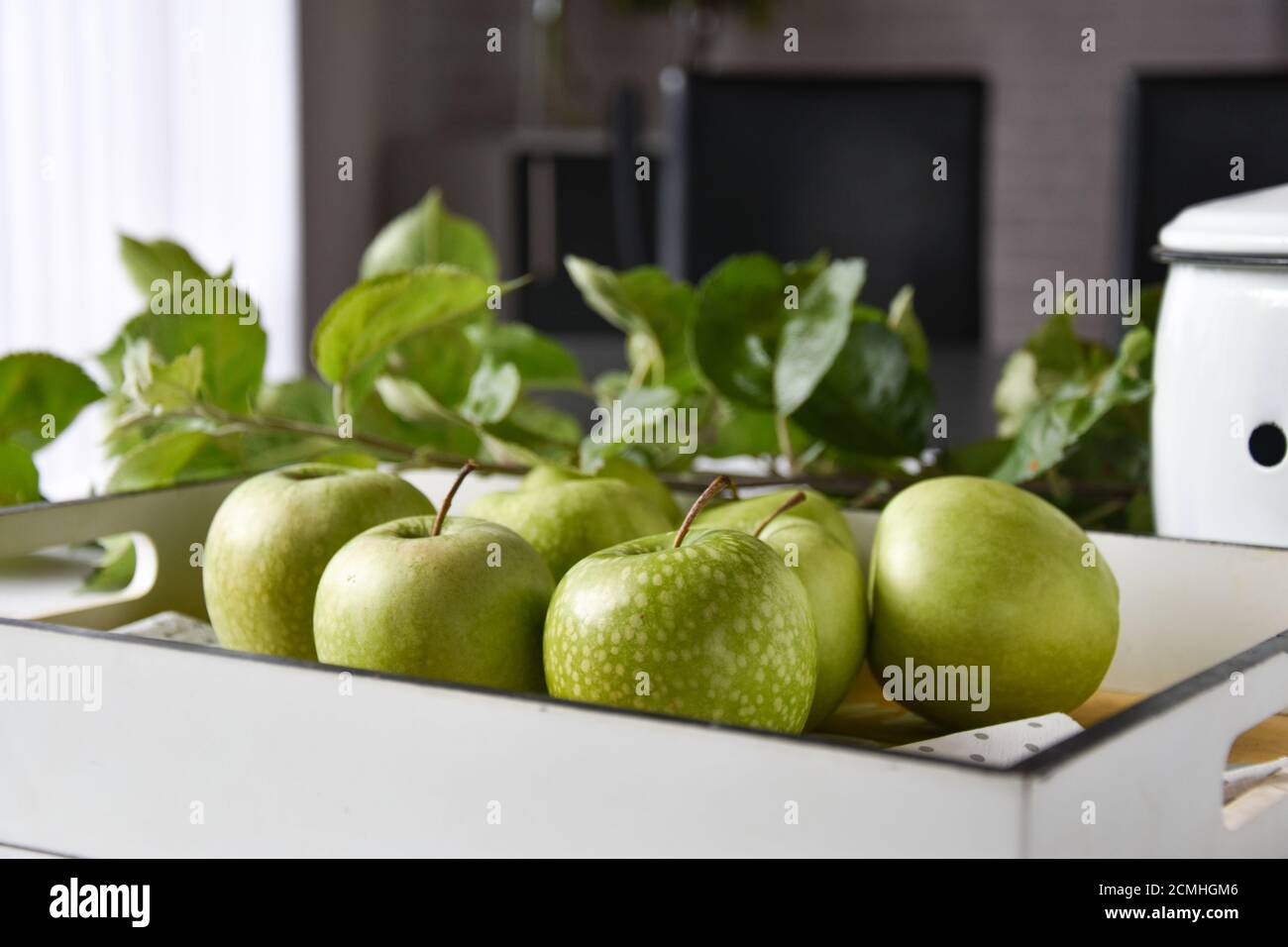 mele verdi su un vassoio di legno servito su un tavolo a casa Foto Stock