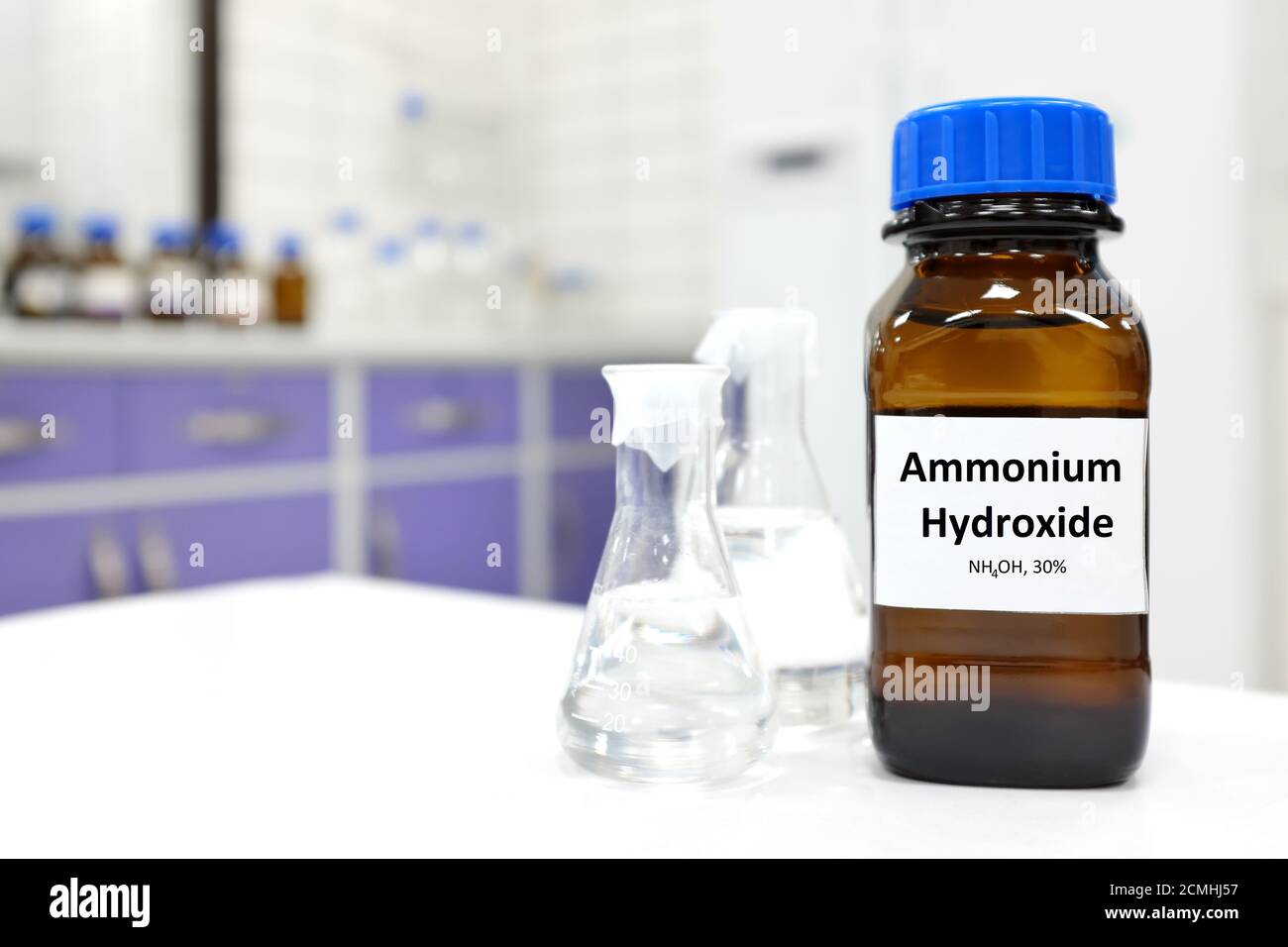 Concentrazione selettiva di idrossido di ammonio o soluzione di ammoniaca in flacone di vetro ambrato all'interno di un laboratorio chimico con spazio di copia. Foto Stock