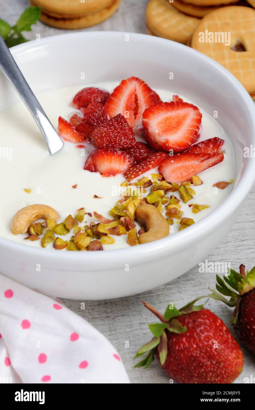 Zuppa di latte alle farfalle ghiacciata di yogurt greco con fragole e pistacchi, anacardi. Servire con i cris Foto Stock