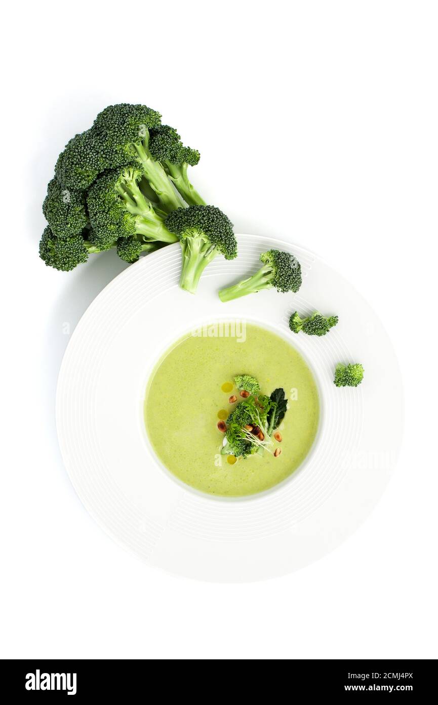 Crema di brodo di broccoli in un piatto bianco su sfondo chiaro. Foto Stock