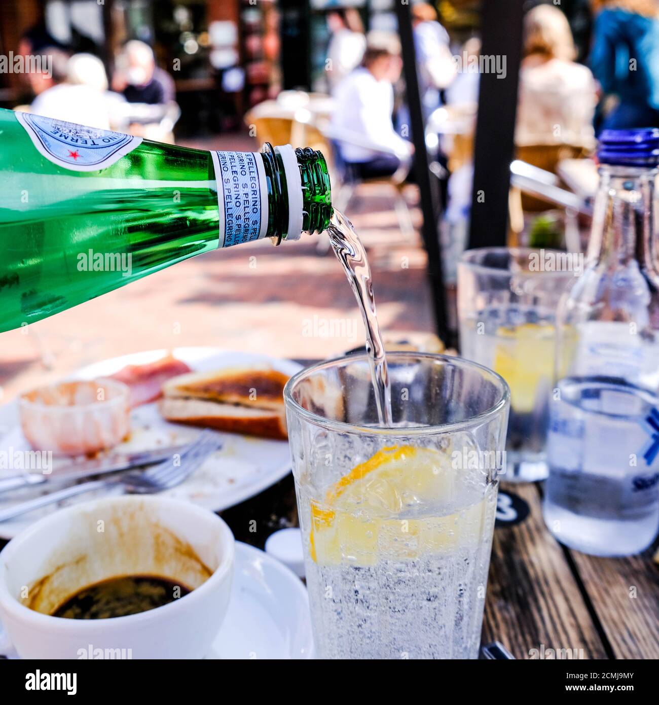 L'acqua minerale viene versata da una bottiglia in un bicchiere, senza persone Foto Stock