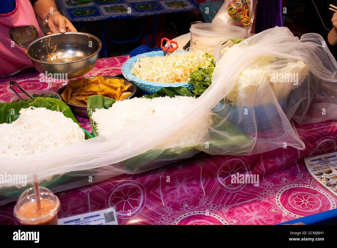 Thailandesi cucina e vendita cibo di strada cucina tailandese per i viaggiatori stranieri thailandesi acquistano e mangiano al mercato di strada locale In serata a Pai città valle collina Foto Stock