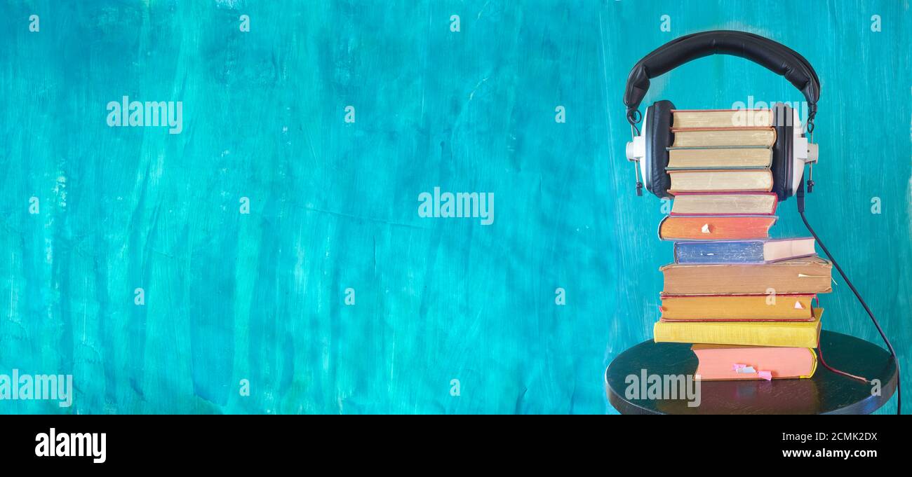 grande mucchio di libri e cuffie vintage, audio libro concetto, panoramico con ampio spazio di copia Foto Stock