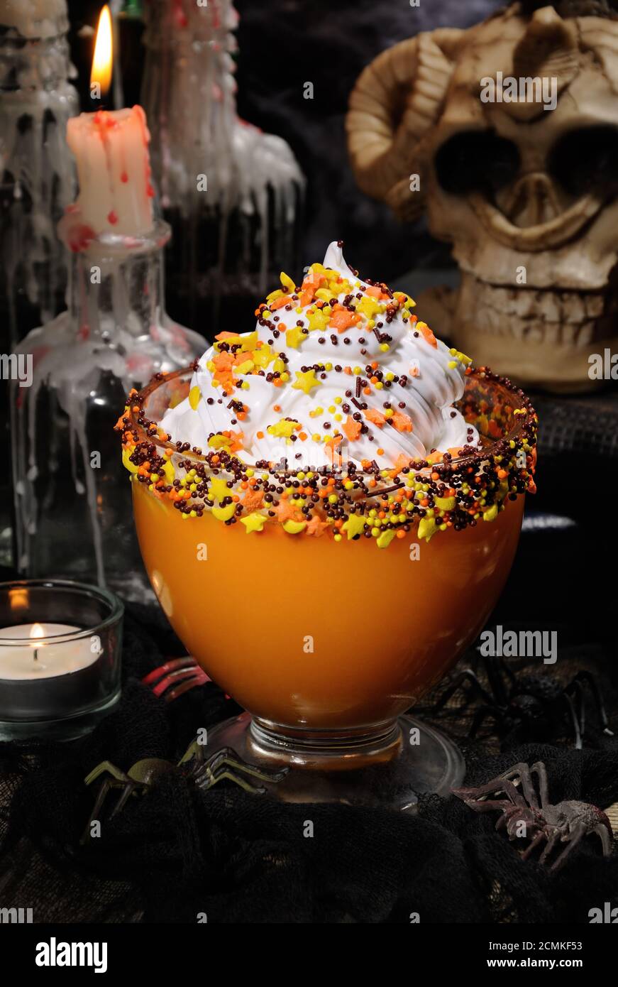 Ciotola con zucca dolce con panna montata sulla tavola tra lo scenario per la festa di Halloween Foto Stock