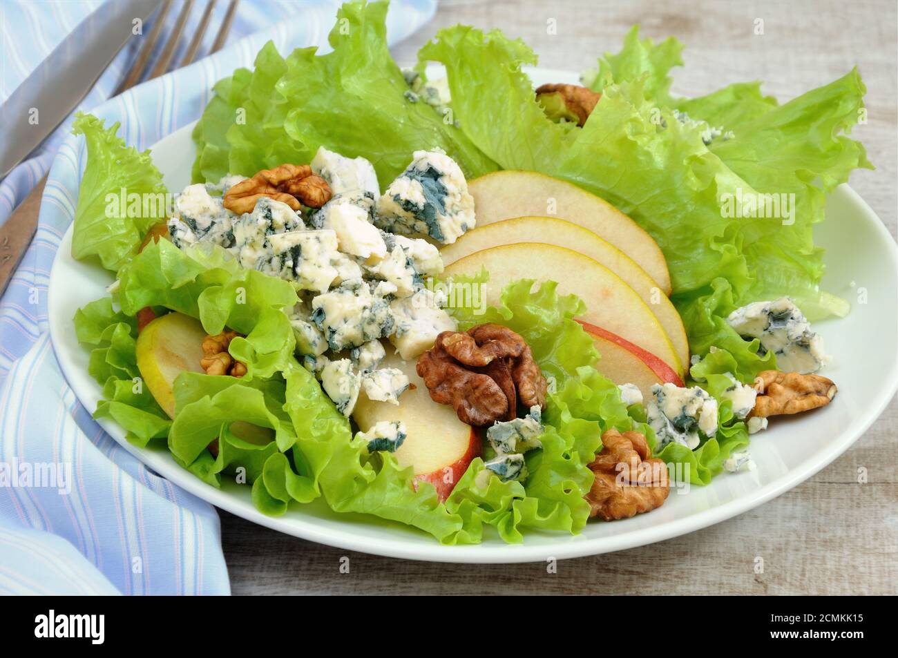Una luce insalata di lattuga con fette di pera, gorgonzola pezzi di legno di noce e condito con olio di oliva Foto Stock