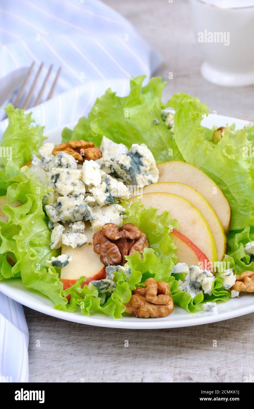 Una luce insalata di lattuga con fette di pera, gorgonzola pezzi di legno di noce e condito con olio di oliva Foto Stock