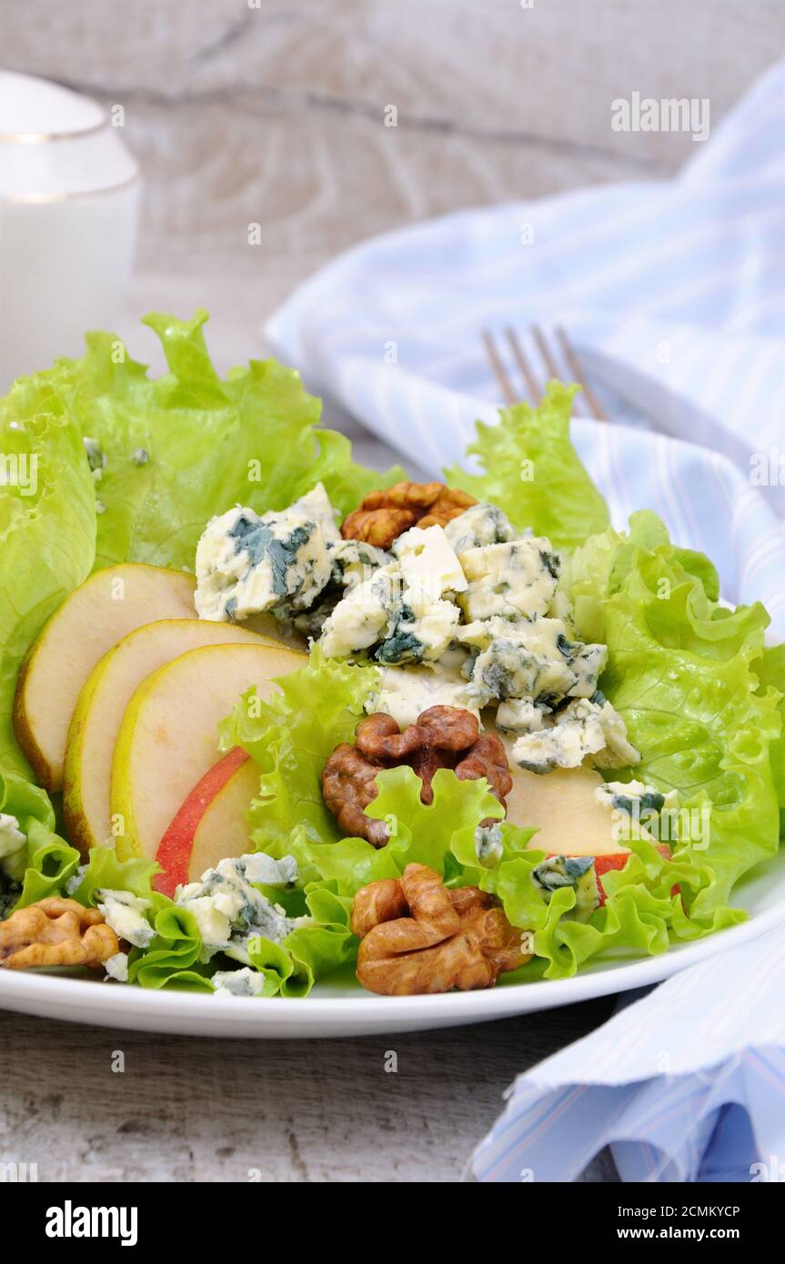 Una luce insalata di lattuga con fette di pera, gorgonzola pezzi di legno di noce e condito con olio di oliva Foto Stock