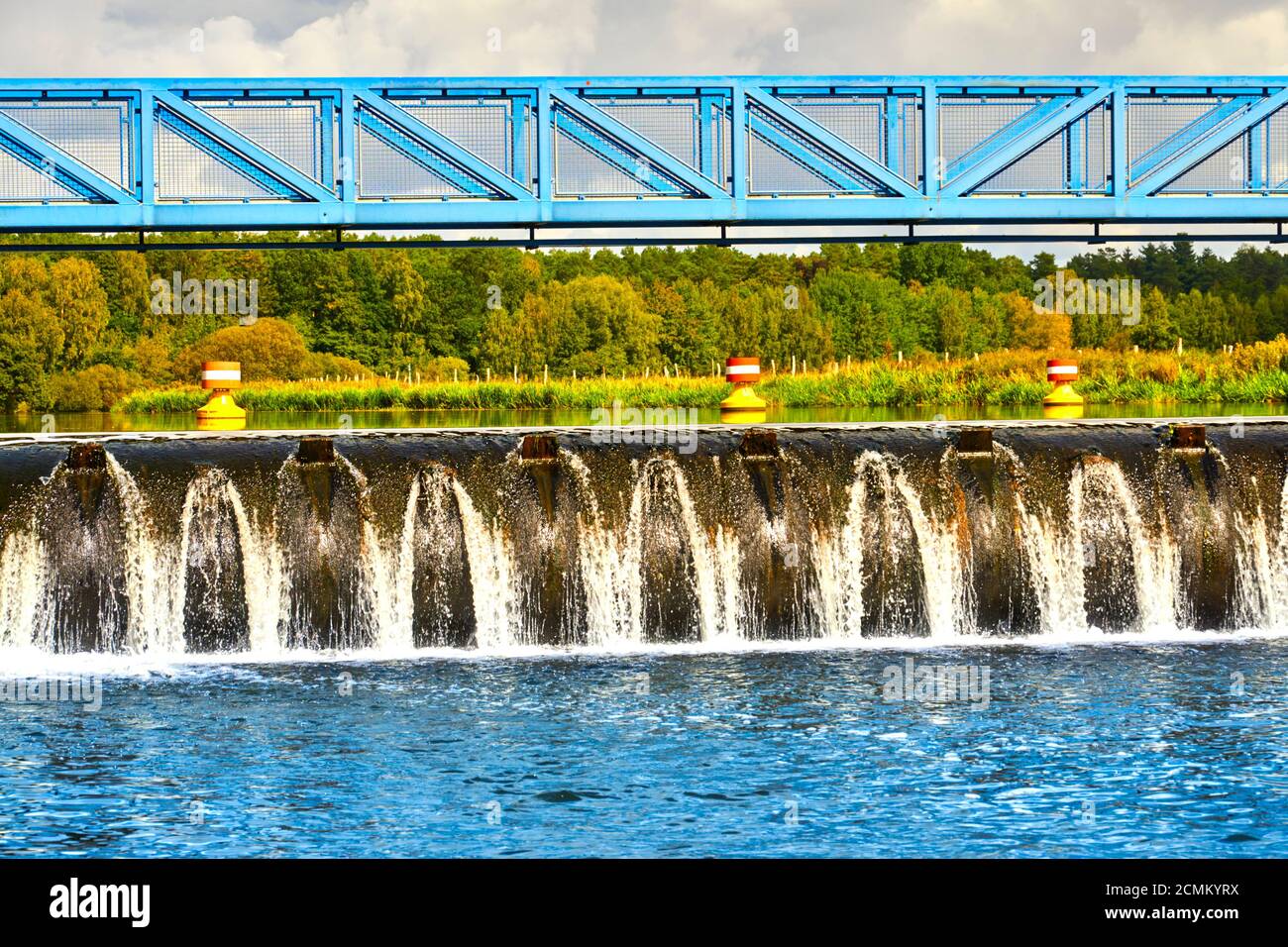 Weir con un ponte pedonale di impalcatura in acciaio blu al fiume aller, Germania Foto Stock