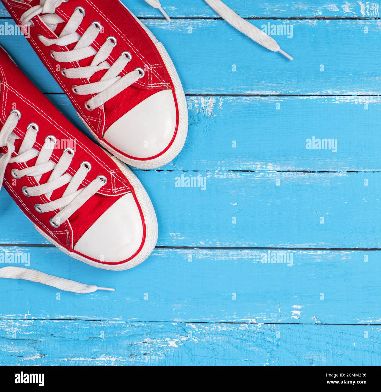 Coppia di tessili rosso sneakers con lacci bianco Foto Stock