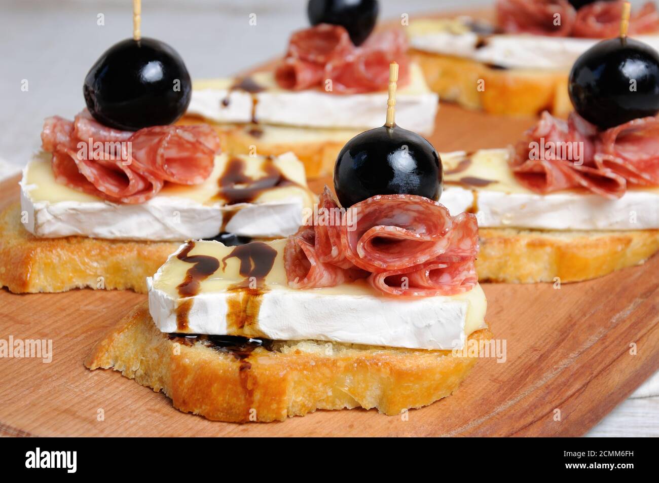 Snack da una fetta tostata di baguette con morbido sotto una muffa bianca nobile Brie formaggio, salame, un berbero Foto Stock