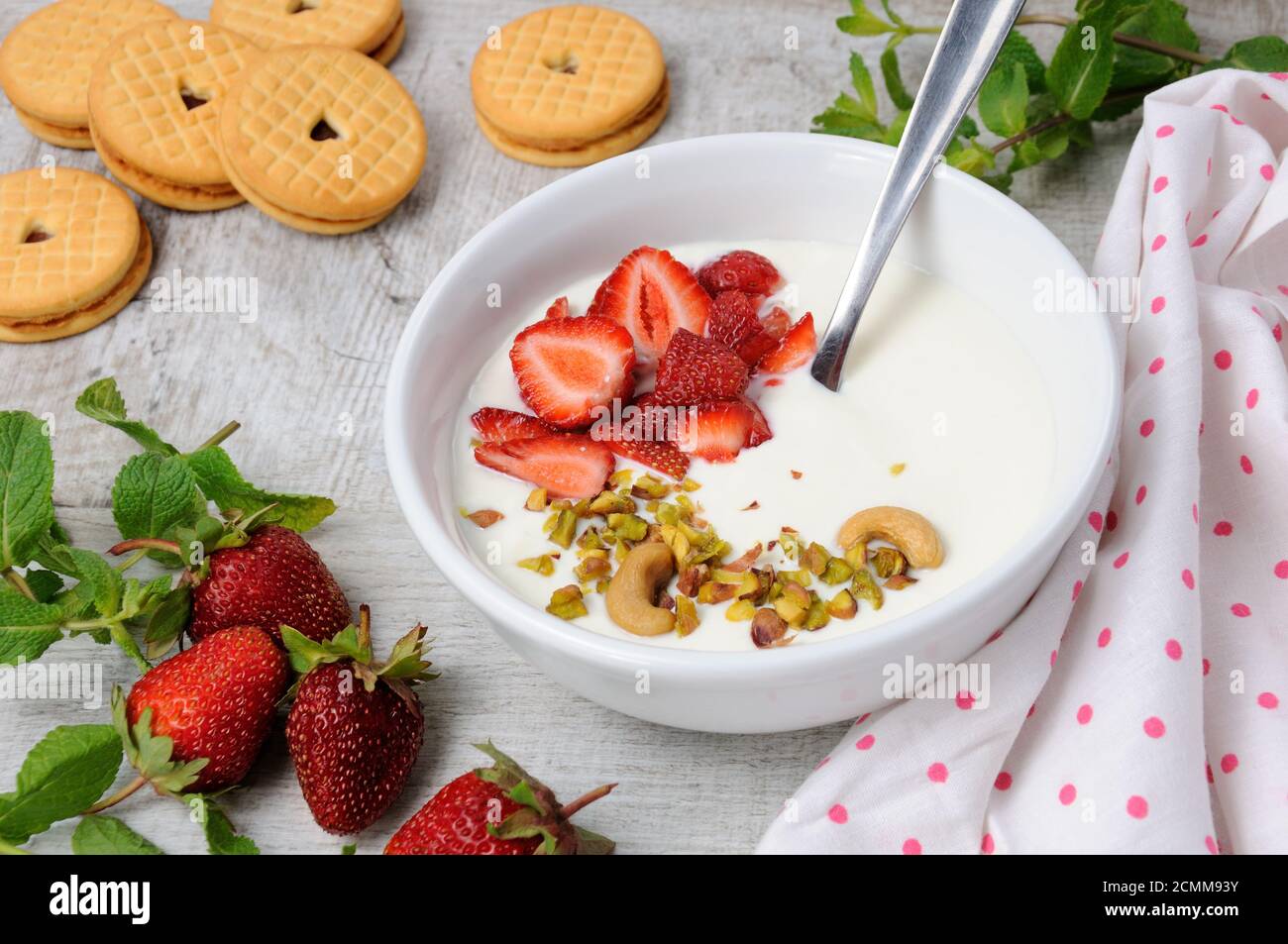 Zuppa di latte alle farfalle ghiacciata di yogurt greco con fragole e pistacchi, anacardi. Servire con i cris Foto Stock
