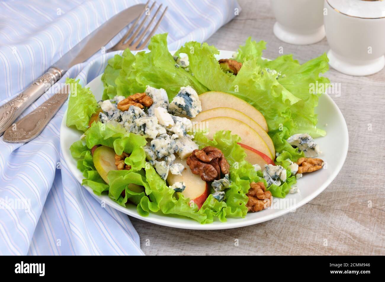 Una luce insalata di lattuga con fette di pera, gorgonzola pezzi di legno di noce e condito con olio di oliva Foto Stock