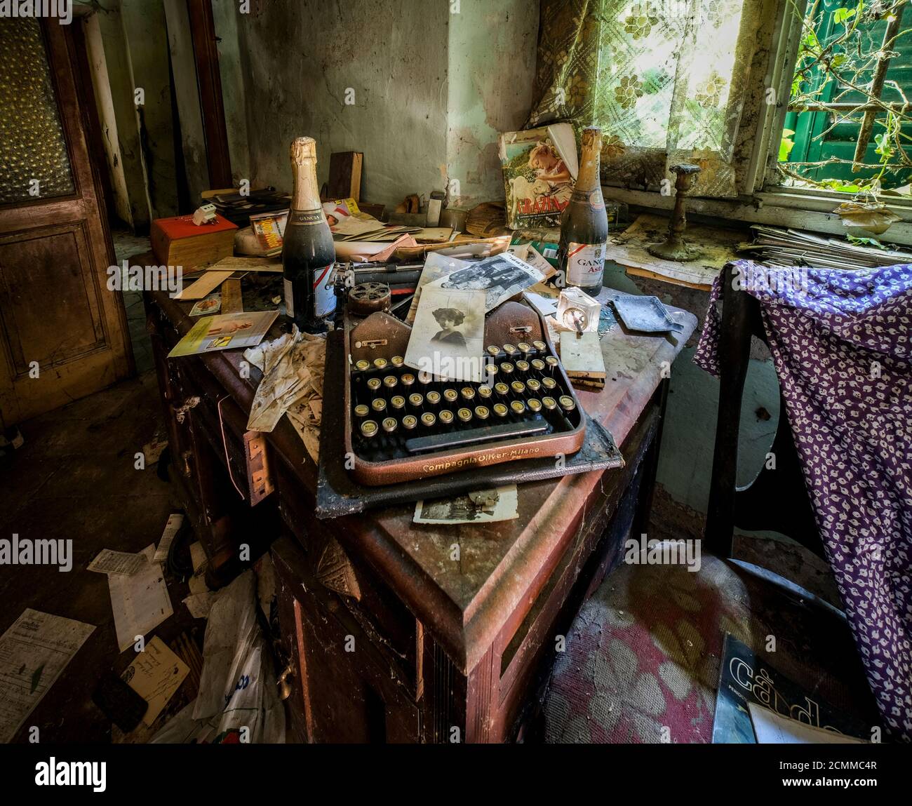 macchina da scrivere e fotografie in una vecchia casa abbandonata con polvere e ciottoli. Foto di alta qualità Foto Stock