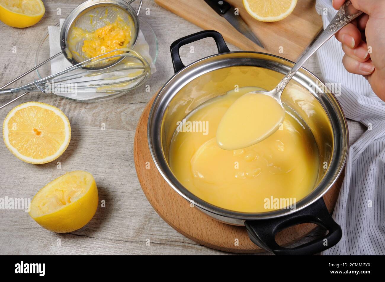 Preparato di fresco curda di limone - crema per il succo di frutta in una casseruola mescolare con un cucchiaio Foto Stock