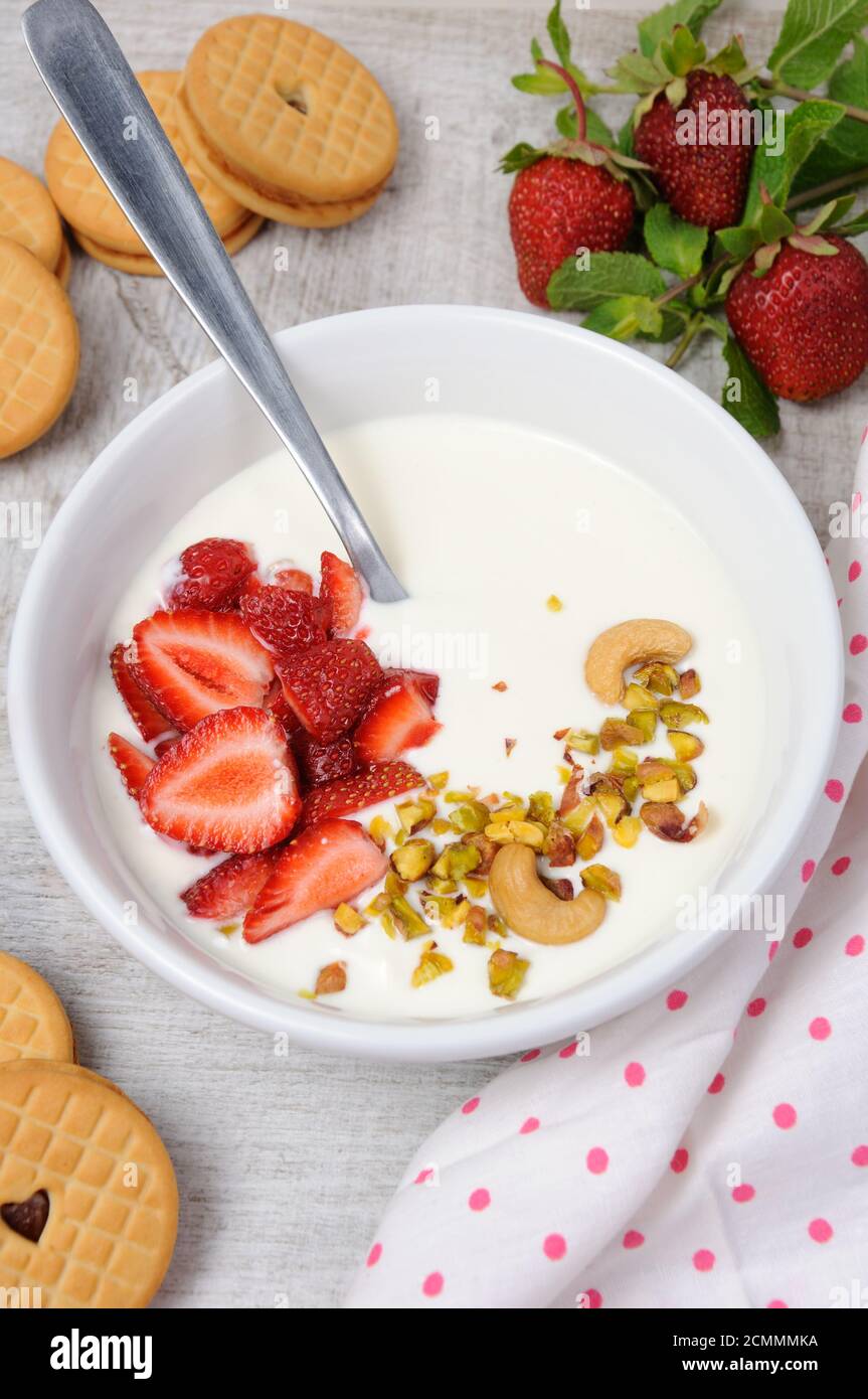 Zuppa di latte alle farfalle ghiacciata di yogurt greco con fragole e pistacchi, anacardi. Servire con i cris Foto Stock