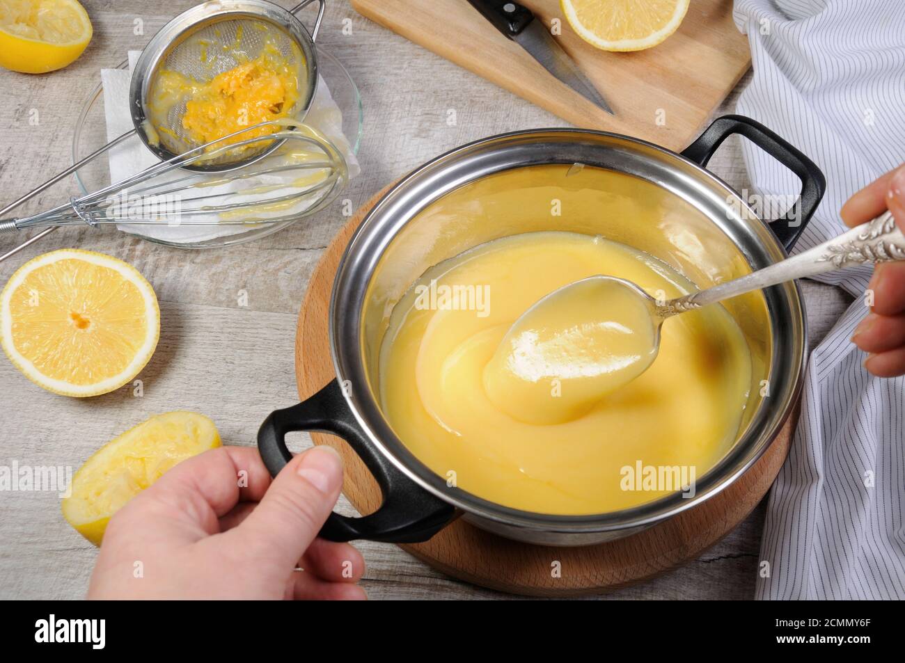 Preparato di fresco curda di limone - crema per il succo di frutta in una casseruola mescolare con un cucchiaio Foto Stock