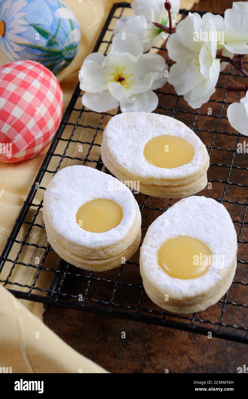 Delicato, fondendo in bocca un biscotto pasquale fatto in casa dalla sabbia sotto forma di un uovo con un Foto Stock