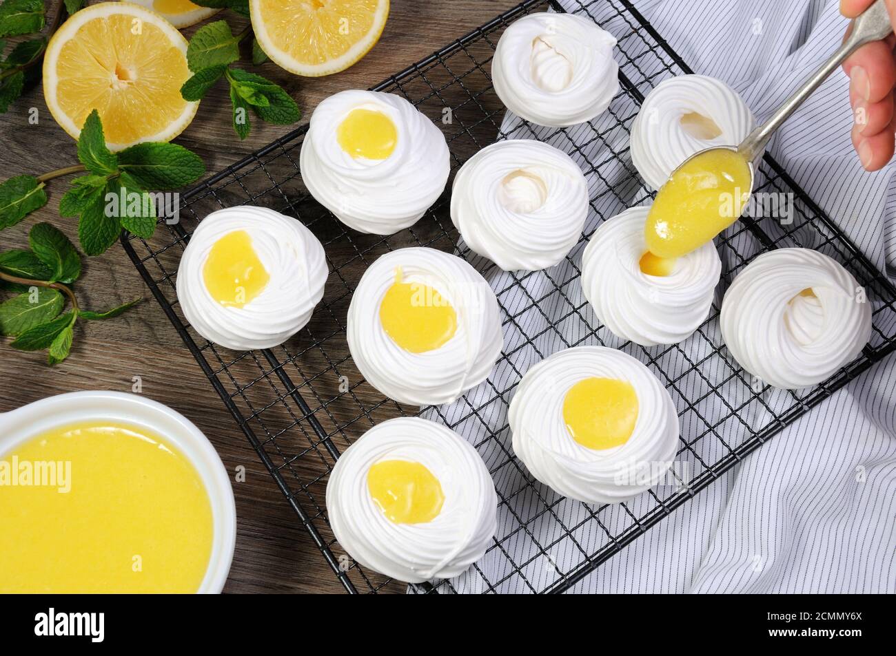 Ripieno con un curd al limone, un mini-dessert delicato e croccante Pavlova sulla griglia Foto Stock