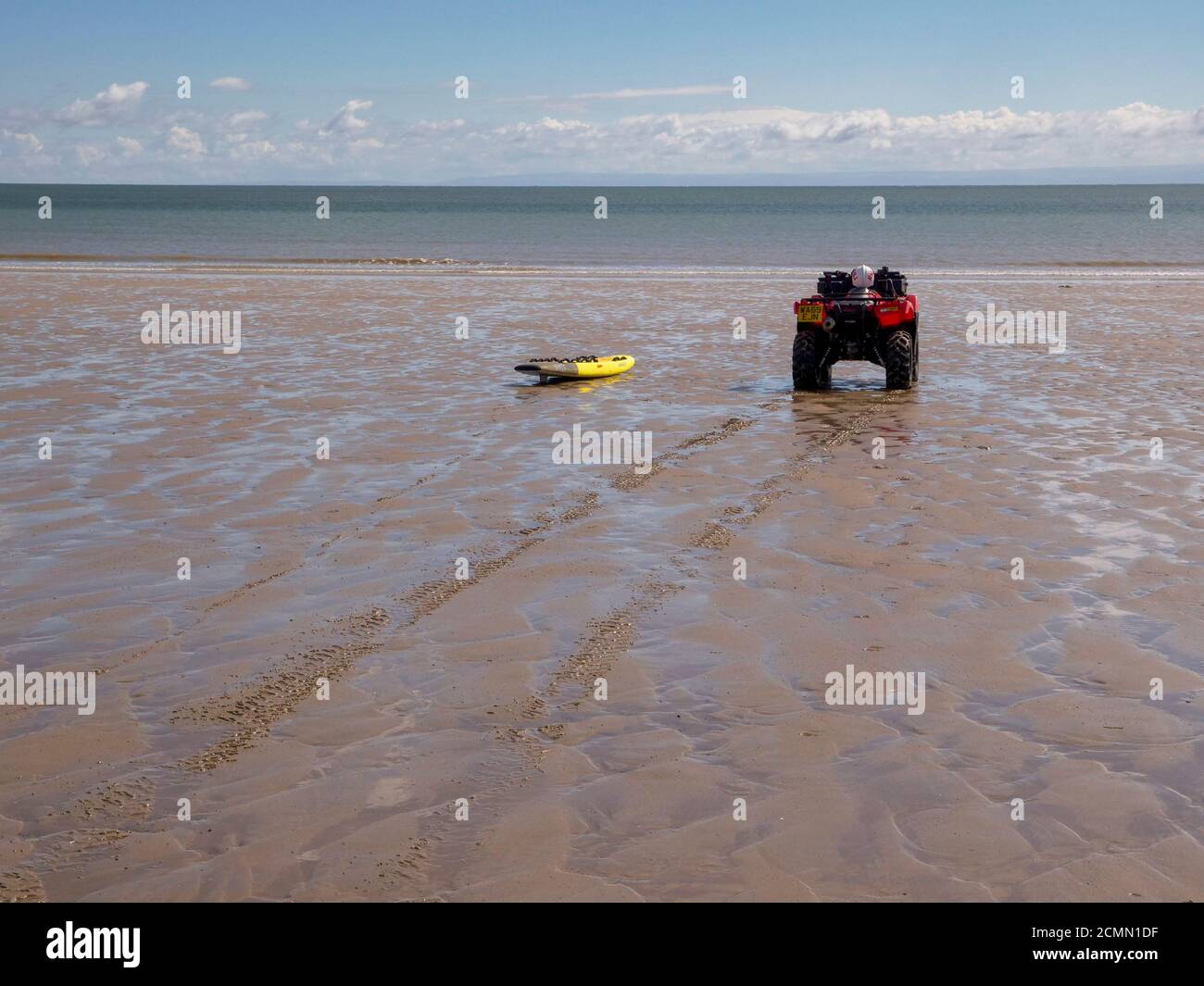 Bagnino in quad e surf sulla spiaggia di Port Eynon sulla Gower Penisula Wales UK Foto Stock