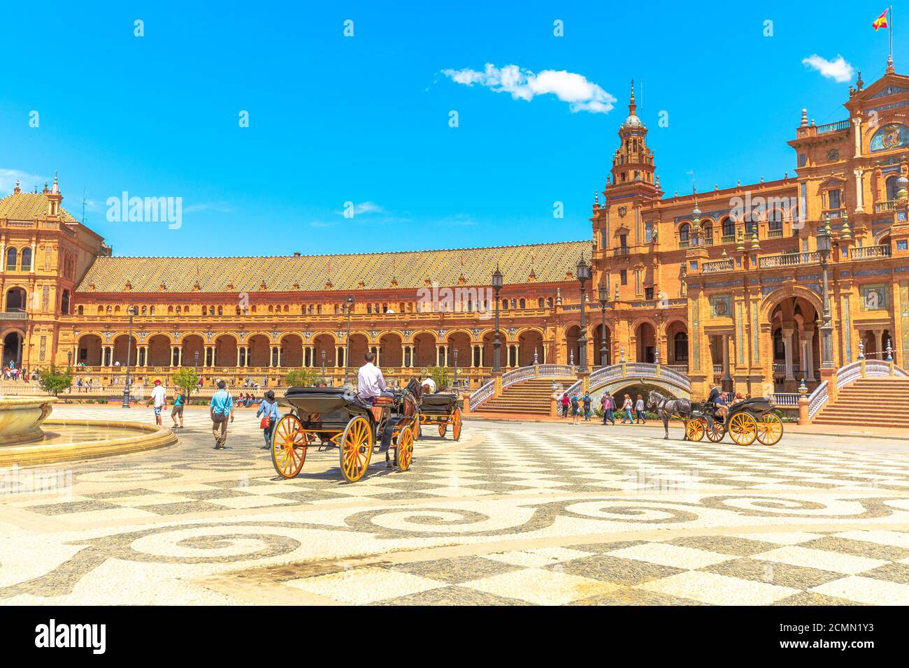 Siviglia, Andalusia, Spagna - 18 aprile 2016: Giro in carrozza a cavallo in Plaza de Espana con edificio centrale con colonne e archi. Piazza della Spagna in un Foto Stock