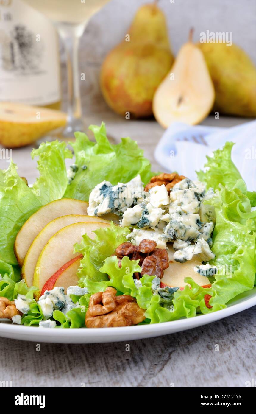 Una luce insalata di lattuga con fette di pera, gorgonzola pezzi di legno di noce e condito con olio di oliva Foto Stock