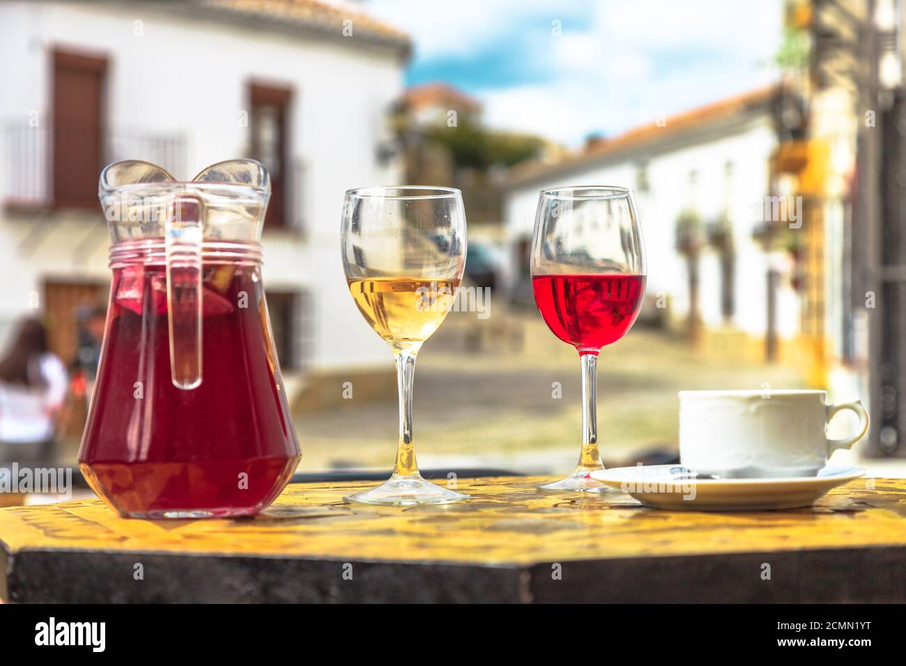 Brocca di sangria con tazza di caffè e bicchieri di vino rosso e bianco su uno sfondo sfocato della campagna spagnola in Spagna. Foto Stock