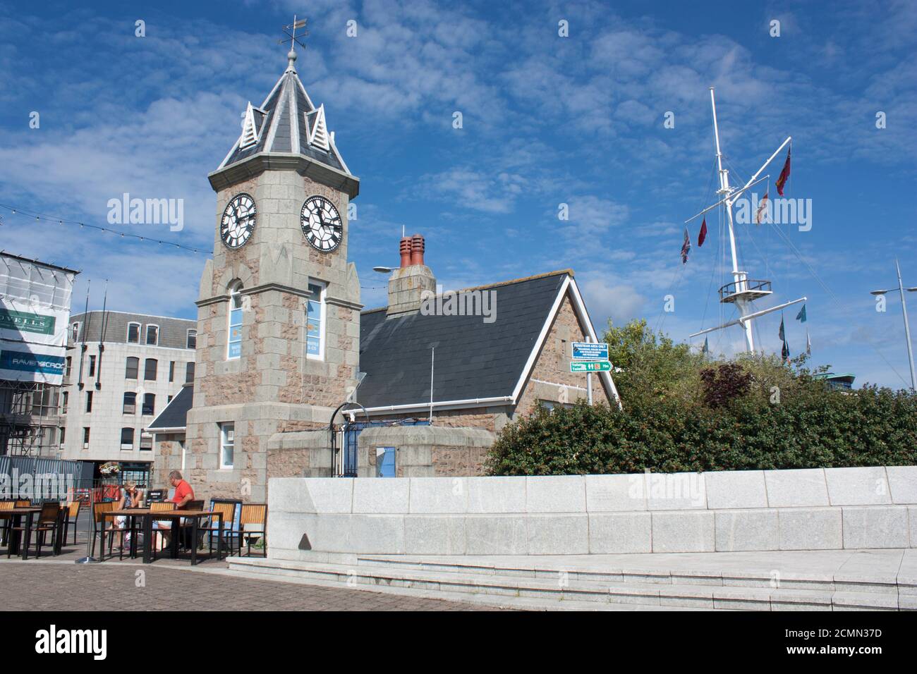 Isole del canale. Guernsey. Porto di San Pietro. Edificio della Torre dell'Orologio con ponte di pesatura e asta della bandiera rotonda. Foto Stock