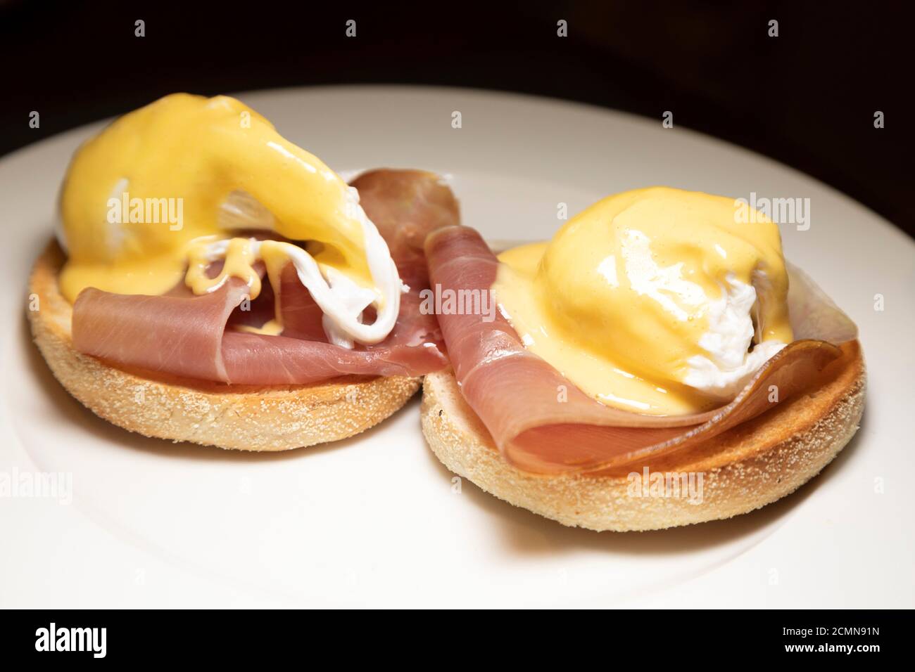 Uova servite da Benedetto per la prima colazione. Il piatto è fatto con uova in camicia, prosciutto e salsa di Hollandaise su un muffin tostato. Foto Stock