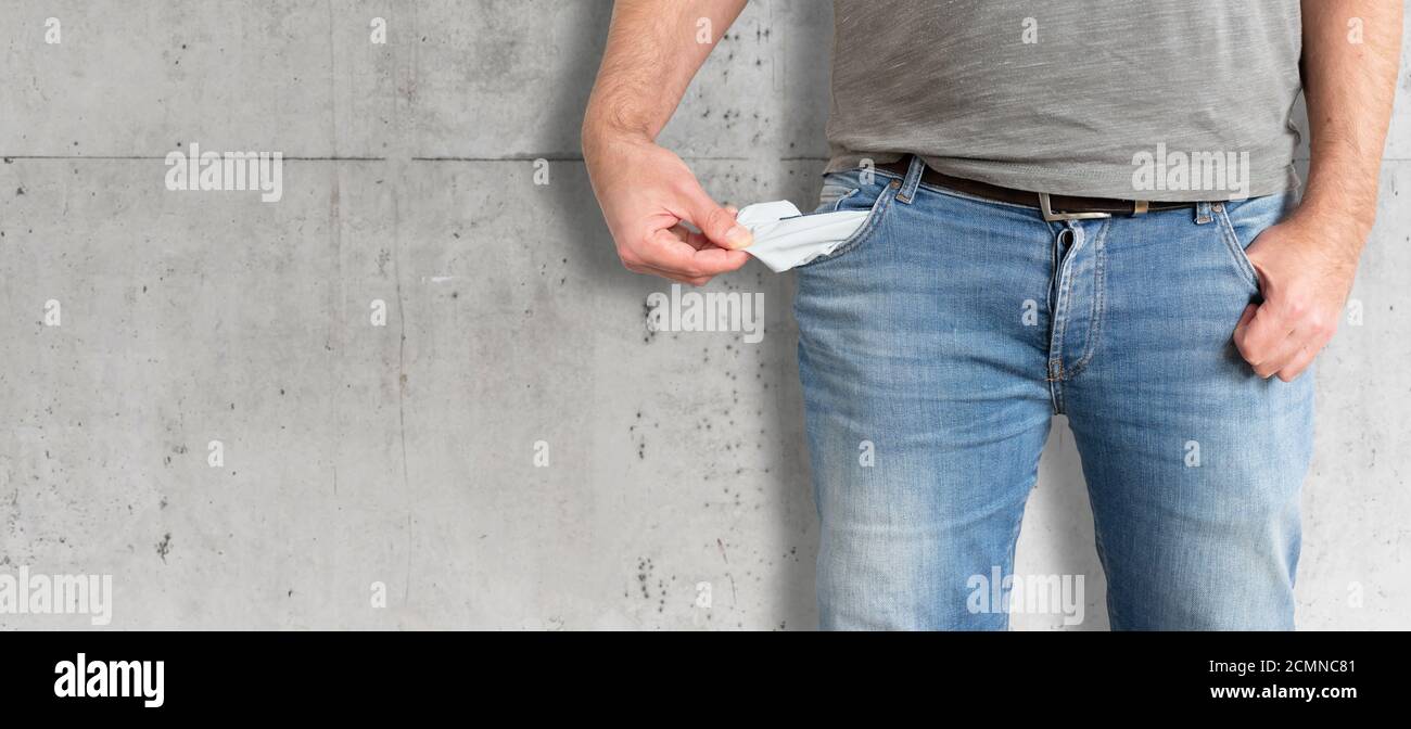 la metà dell'uomo che gira le sue tasche vuote dentro, non avendo soldi ed essendo rotto il concetto Foto Stock
