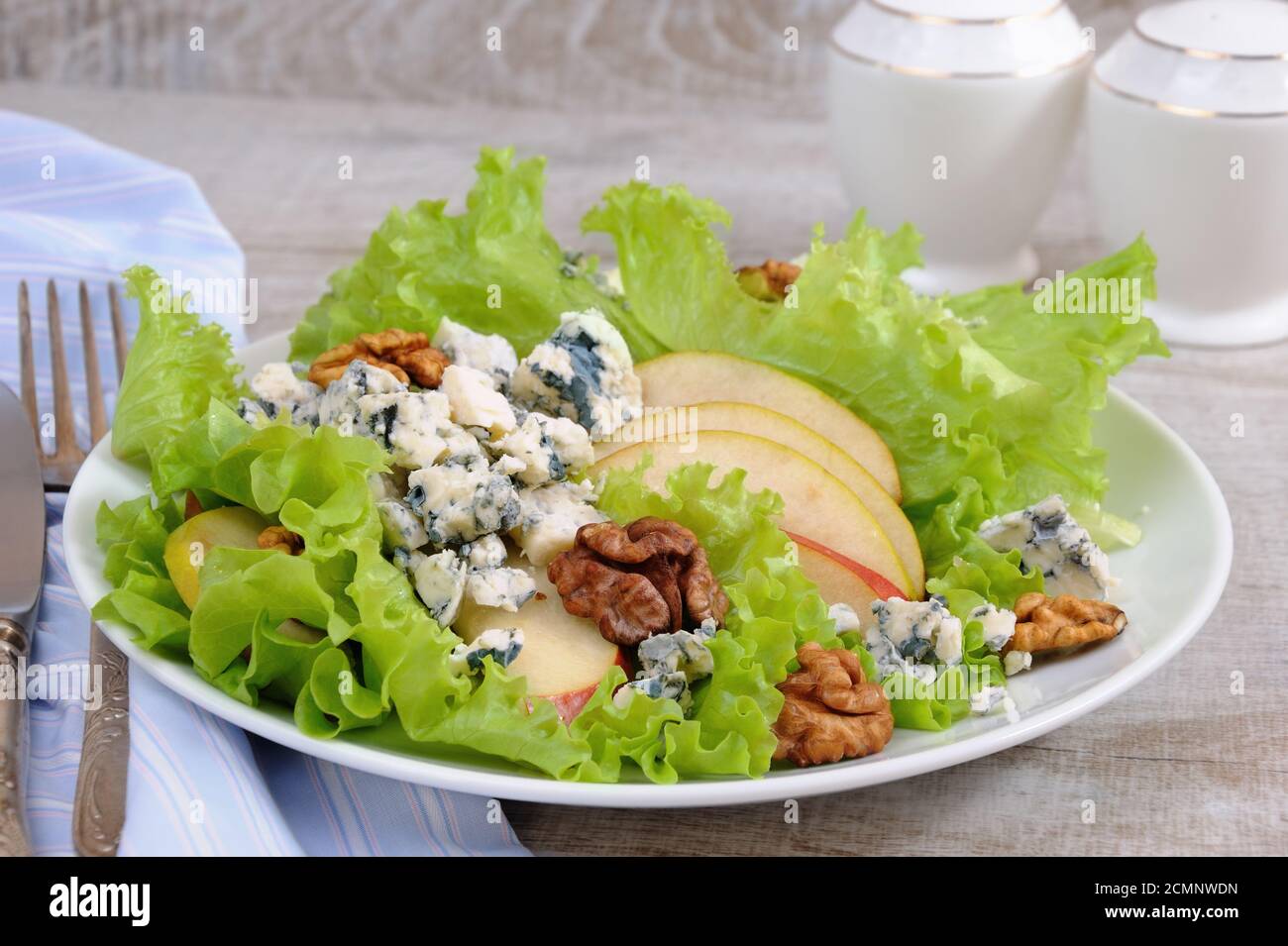 Una luce insalata di lattuga con fette di pera, gorgonzola pezzi di legno di noce e condito con olio di oliva Foto Stock