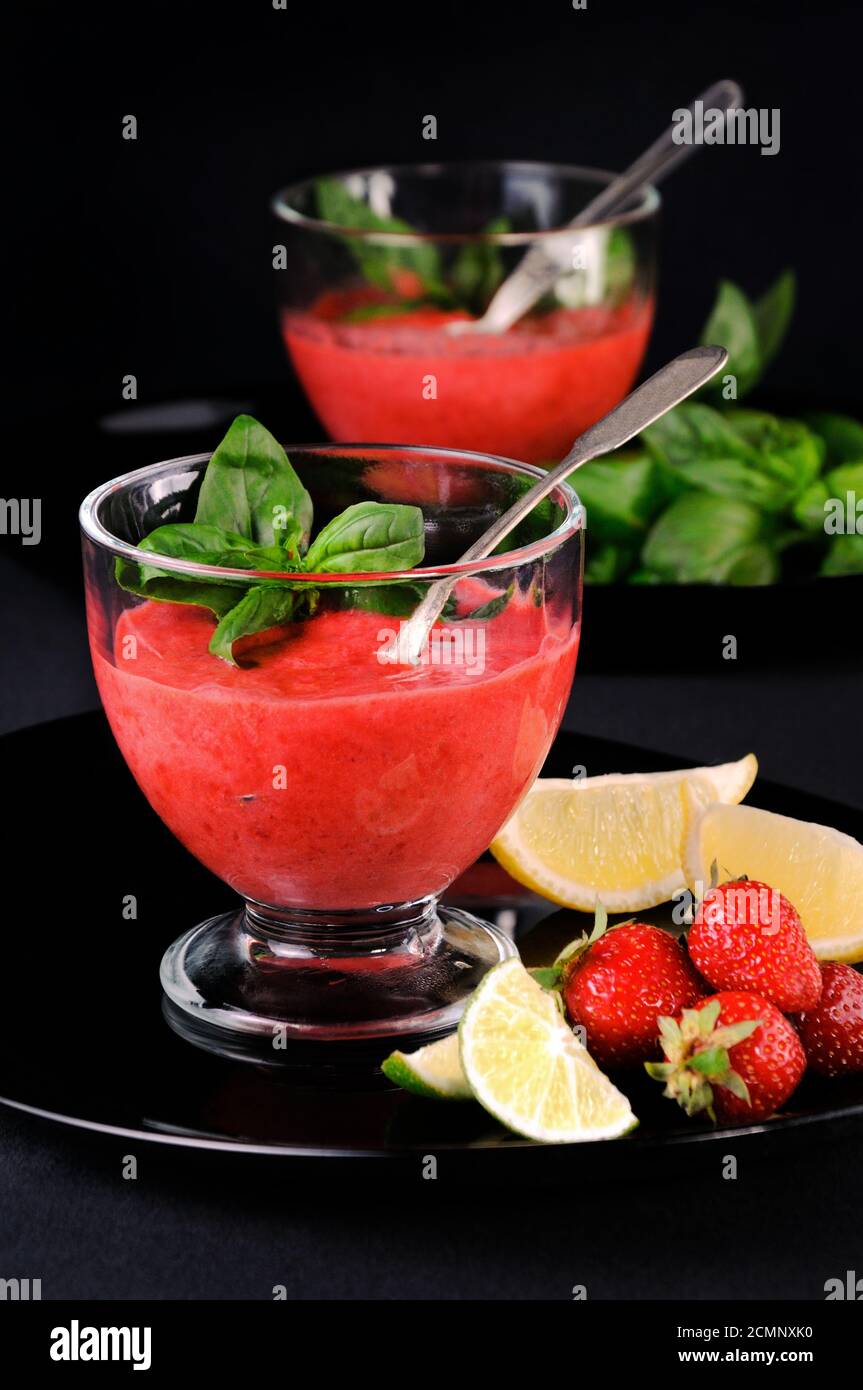 Frullati estivi di fragole con basilico, lime e miele, ricetta sana e rinfrescante. Un delizioso A. Foto Stock