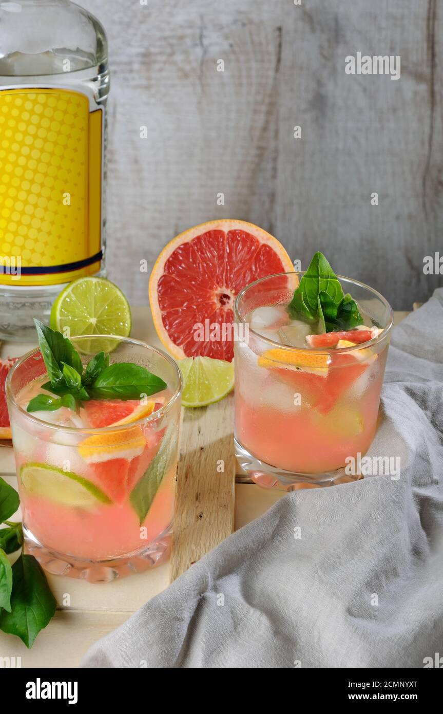 Cocktail dal gin secco londinese con succo di rosso spremuto pompelmo e foglie di basilico delicato di Foto Stock