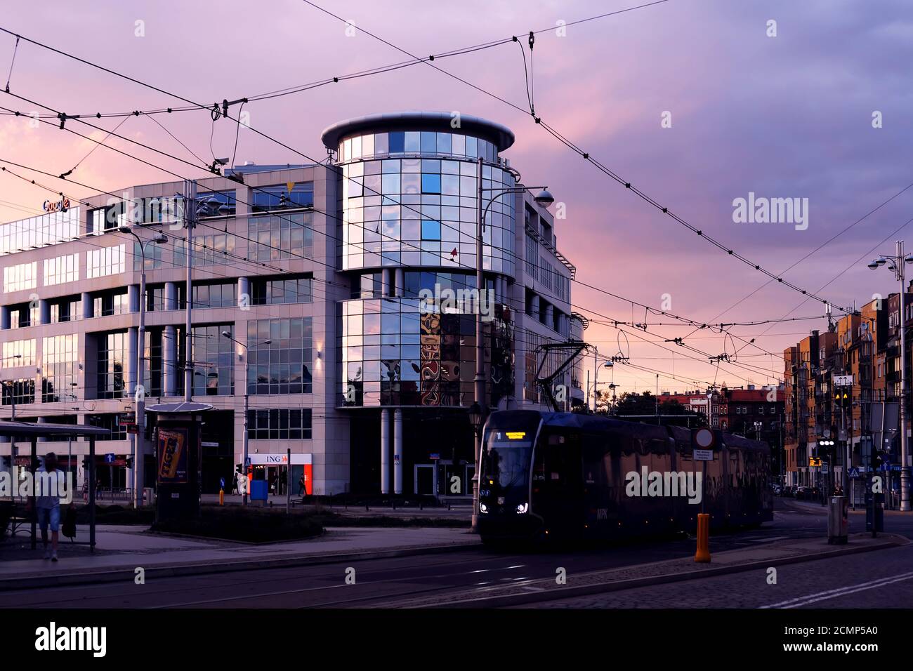 Wroclaw, Polonia. Tram 08/28/2020 arrivo a una fermata dell'autobus di fronte ad un moderno edificio di uffici Bema Plaza a Bema Street al tramonto Foto Stock