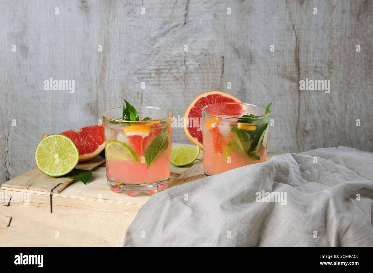 Cocktail di succo di pompelmo rosso spremuto e foglie di limone basilico delicato, fette di lime e peperoncino Foto Stock