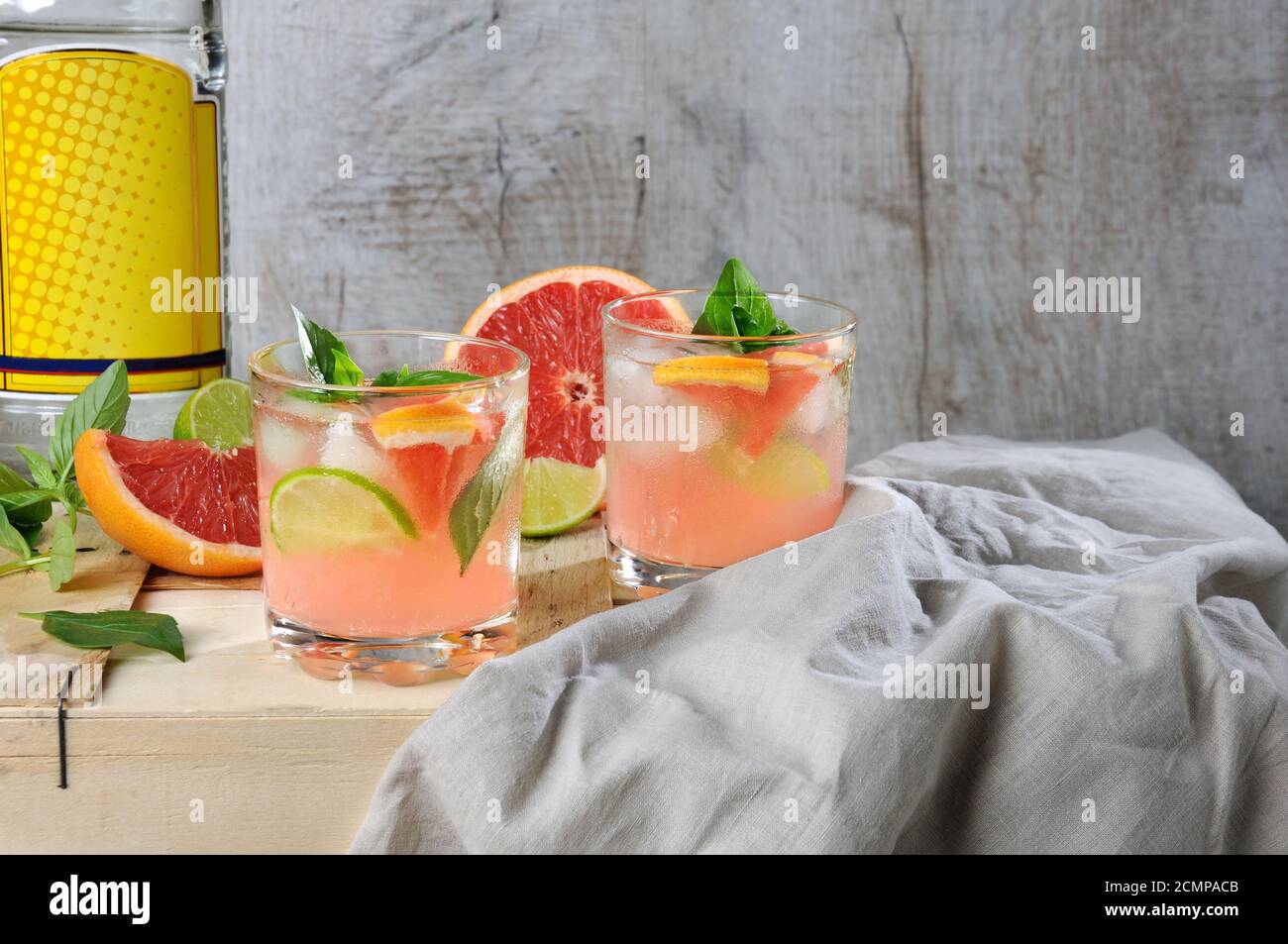 Cocktail di succo di pompelmo rosso spremuto e foglie di limone basilico delicato, fette di lime e peperoncino Foto Stock